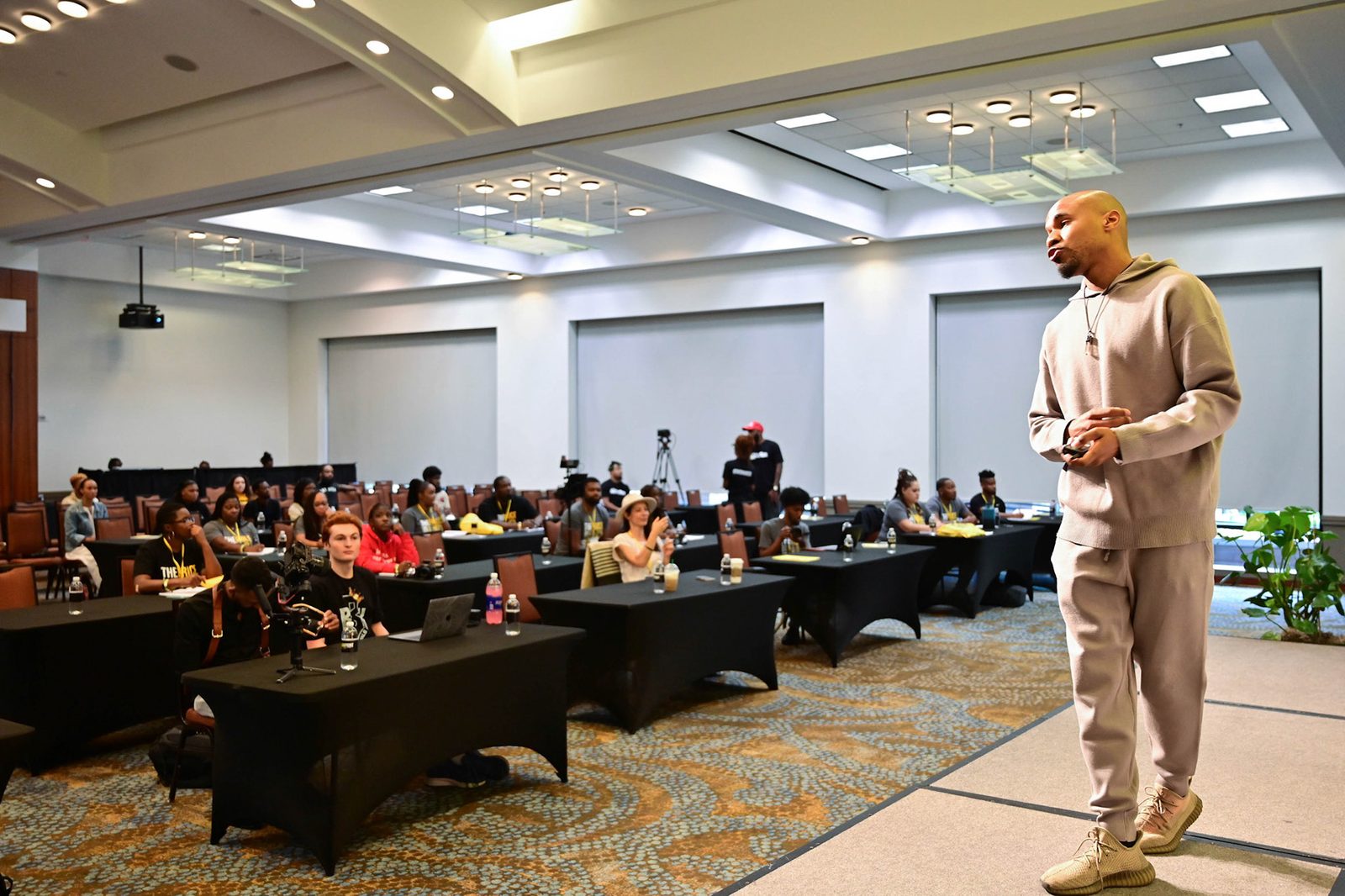 Akil Wade speaking to a full conference room